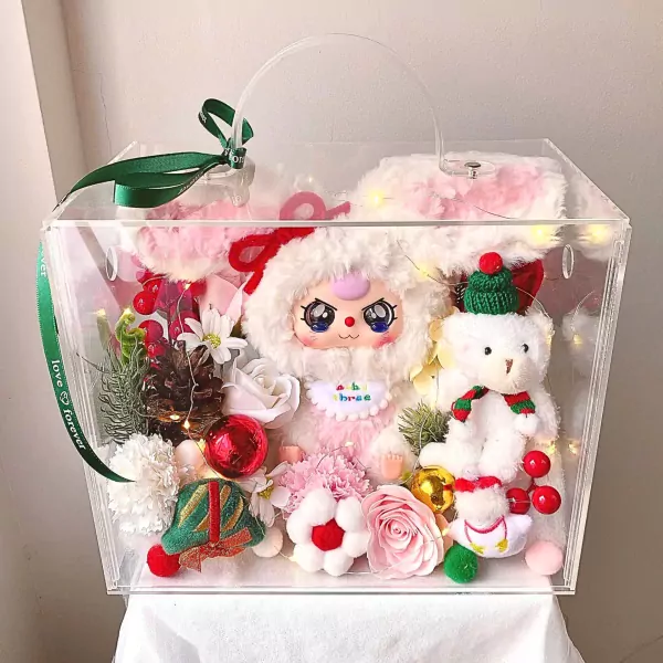 Clear box filled with a plush bunny, teddy bear, flowers, and Christmas decor.