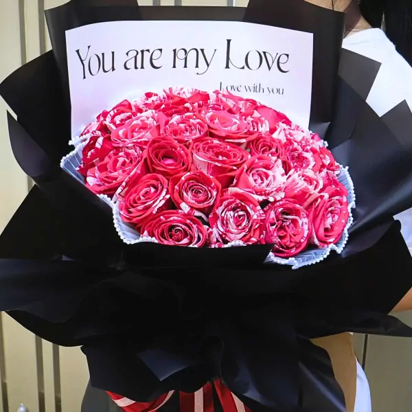 Bouquet of red and white striped roses wrapped in black paper with "You are my Love" card.