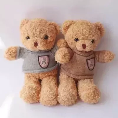 Two tan teddy bears in gray and brown sweaters.
