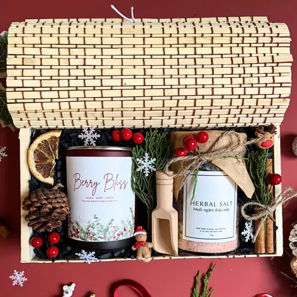 Christmas gift set with candle, herbal salt, pinecone, dried orange, cinnamon, and berries.