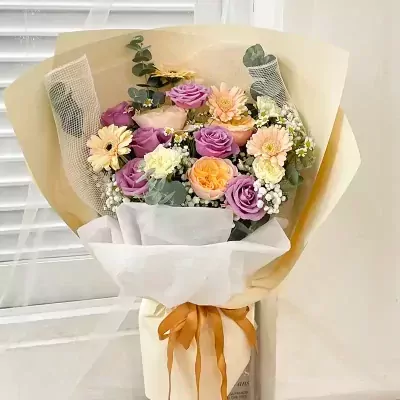 Bouquet of purple roses, orange roses, yellow gerberas, and white carnations.