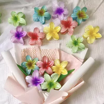 Flower-shaped hair clips arranged in a bouquet, in various bright colors.