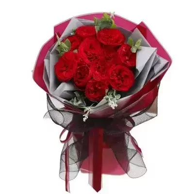 A bouquet of red Ohara roses with greenery, wrapped in pink and gray paper, tied with a black ribbon.