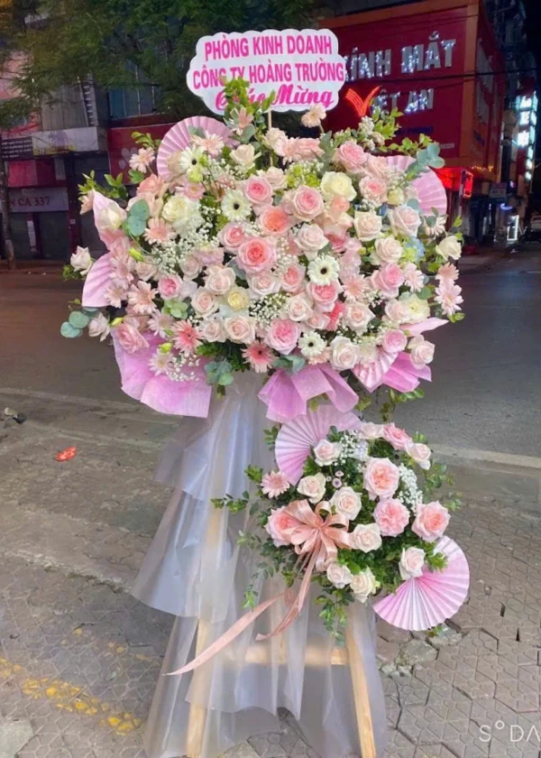 Large floral arrangement in soft pinks and whites, featuring roses and gerbera daisies.