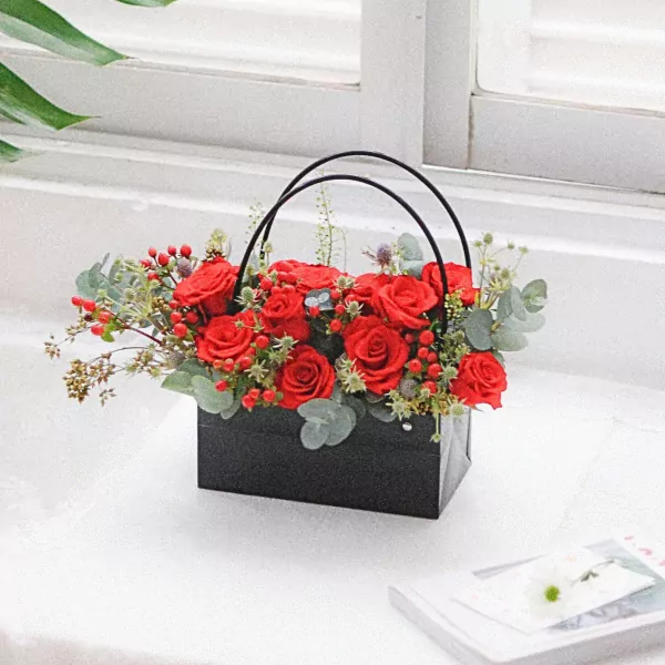 Red roses in a black square basket with handles.