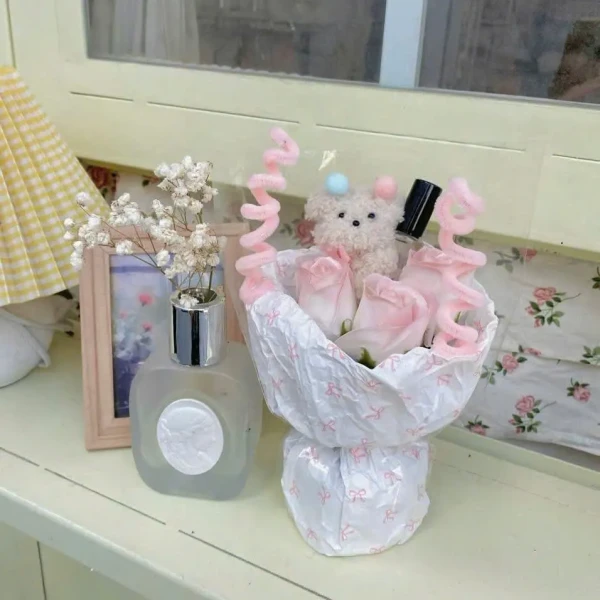 A bouquet with pink roses and a teddy bear.