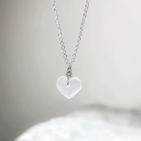 Silver necklace with a raw, clear quartz heart pendant.