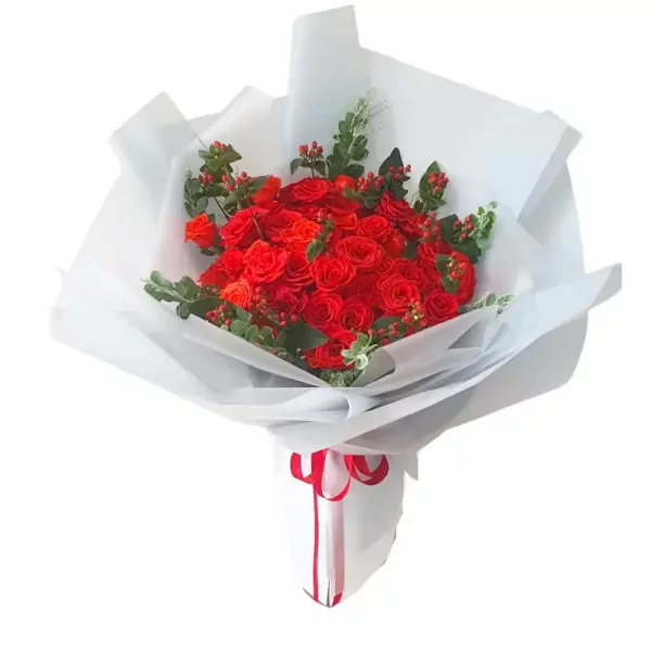 A bouquet of red roses wrapped in white paper with a red ribbon.