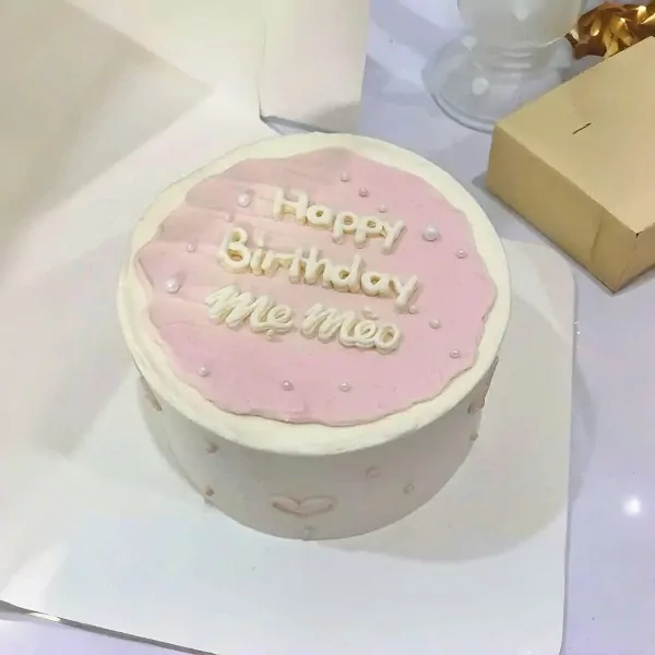 Pink cake with "Happy Birthday Me Meo" written on top in white icing.