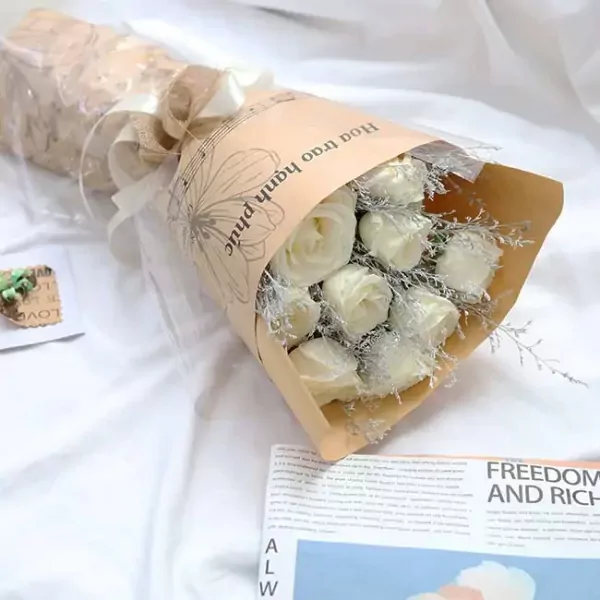 Bouquet of white roses with delicate wrapping and a newspaper.