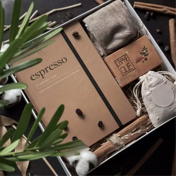 Espressiano gift set with notebook, socks, coffee, and cinnamon sticks.