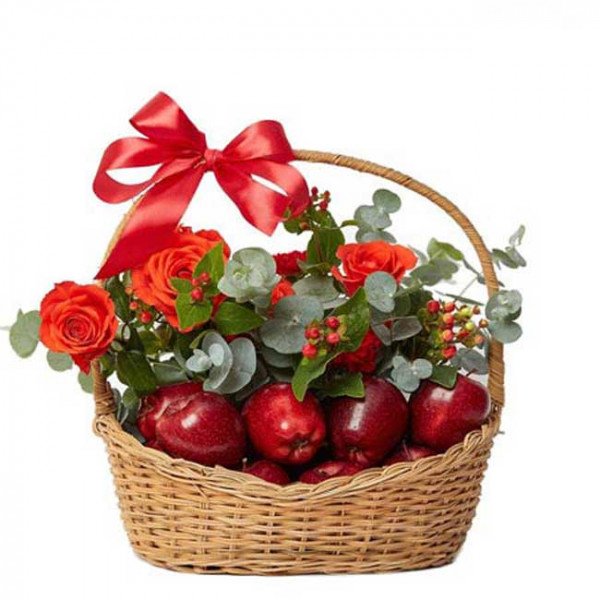 Wicker basket filled with red apples and orange-red roses, adorned with a red bow.