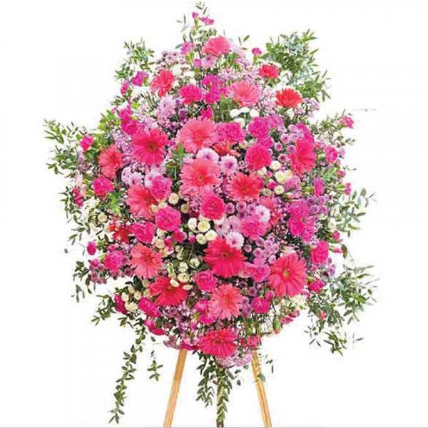 A large, lush floral arrangement in various shades of pink, featuring gerbera daisies, carnations, and chrysanthemums.