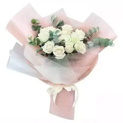 Bouquet of white roses and eucalyptus leaves, wrapped in pink and white paper with a ribbon.