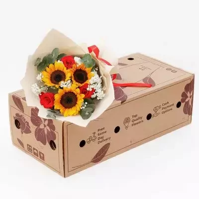 Bouquet of sunflowers and red roses on a cardboard box.