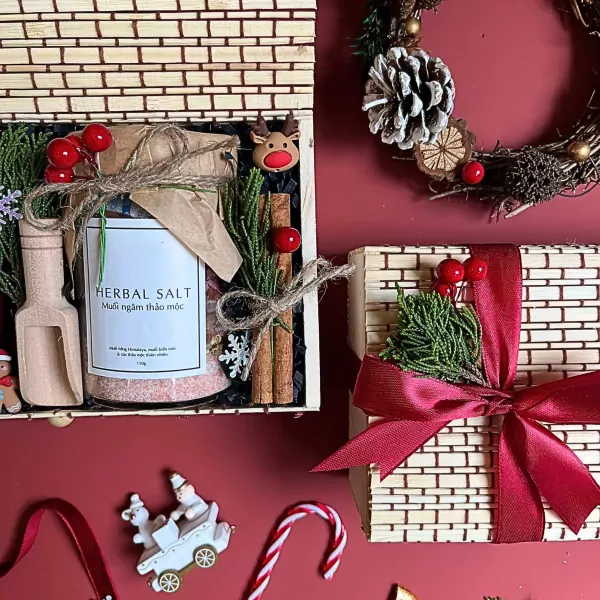 Christmas gift set in bamboo box with herbal salt, cinnamon, pine branches, and berries.