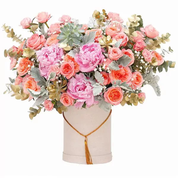 Pink peonies, coral roses, and succulents in a blush pink box with a gold tassel.