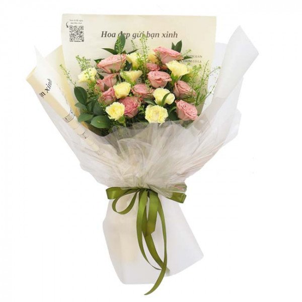 Bouquet of pink cappuccino roses and yellow carnations wrapped in white paper with a green ribbon.