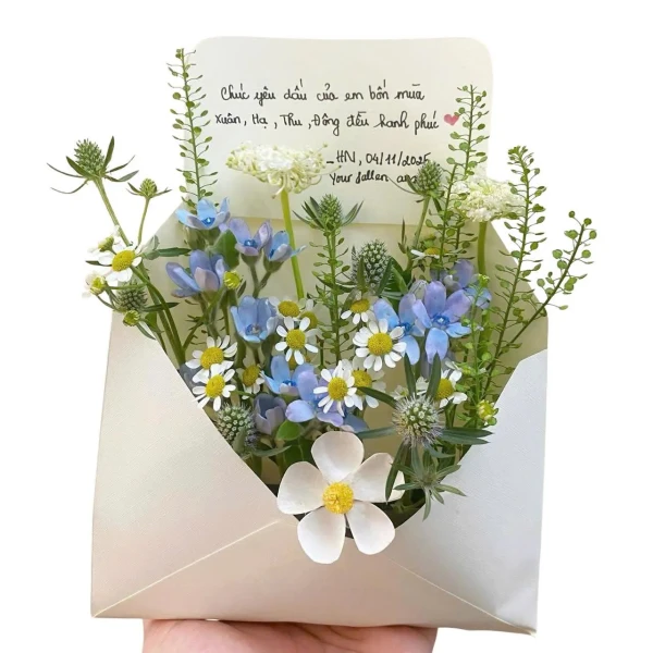 A flower card in the shape of an envelope with a bouquet of blue and white flowers and a handwritten message.