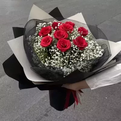 Deluxe Felicity bouquet with 9 red roses and baby's breath, wrapped in black and white paper.