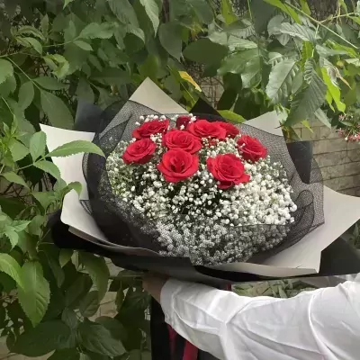 Bouquet of 9 red roses and baby's breath, wrapped in black and white paper.