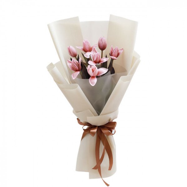 Bouquet of pink tulips wrapped in cream paper with a brown ribbon.