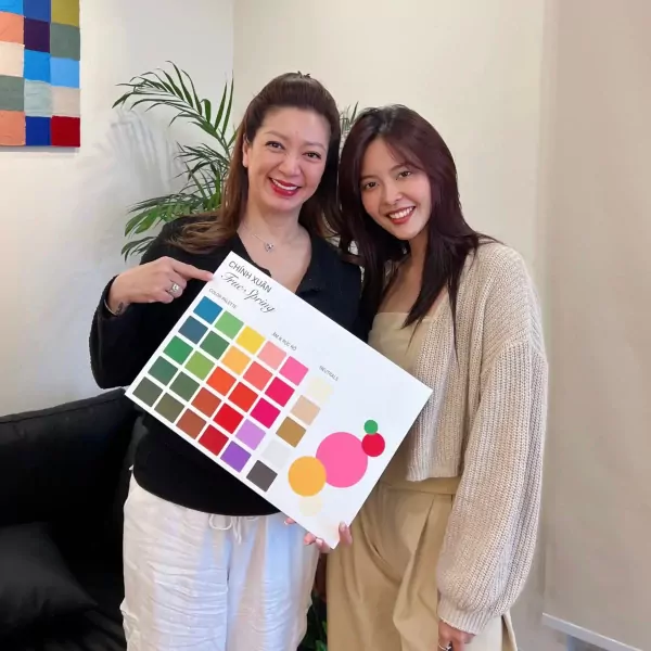 Two women hold a color palette labeled "True Spring" with swatches of various colors.