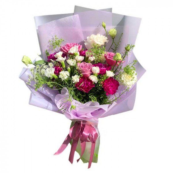 Bouquet of pink roses, white carnations, and white eustoma, wrapped in light purple paper and tied with a pink ribbon.