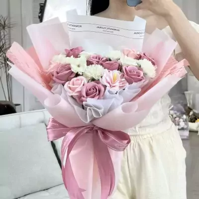 Pink and white bouquet of roses and daisies with pink ribbon.