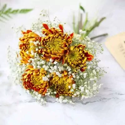 Bouquet of yellow and brown chrysanthemums and baby's breath flowers for a wedding.