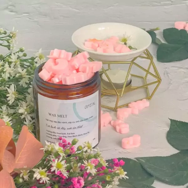 Jar of pink wax melts with flowers and a wax warmer.