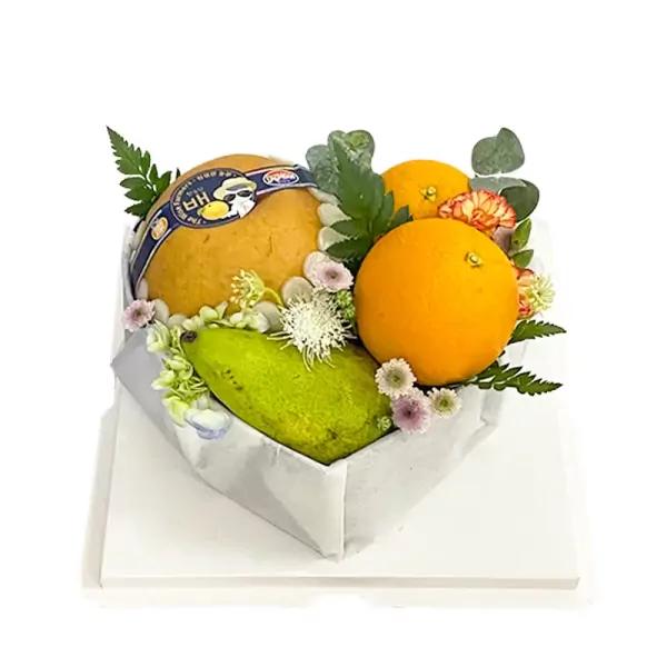 Heart-shaped box of assorted fruits including pear, orange, and green fruit with decorative flowers.