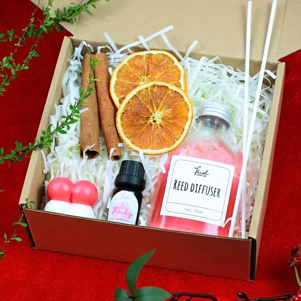 Gift box with reed diffuser, essential oil, cinnamon sticks, dried oranges, and novelty candles.