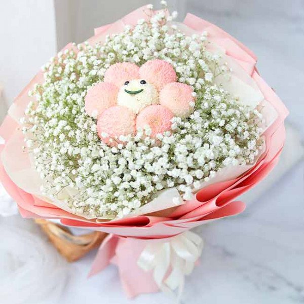 Bouquet of pink ping pong chrysanthemums and baby's breath with a cute smiley face decoration.