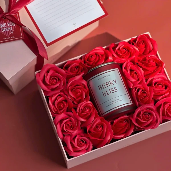 Gift box with red roses and a Berry Bliss candle, a pink box with a red ribbon and card.