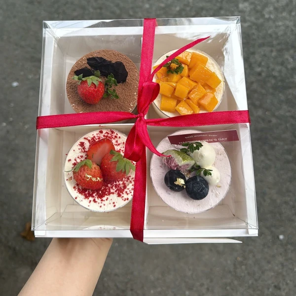 Gift box of four mini cakes: tiramisu, strawberry, mango, and berry flavored.
