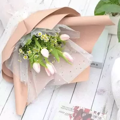 Pink tulips and tiny white flowers in a blush pink and sheer starry wrap.