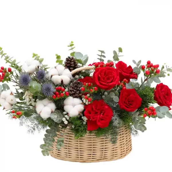 Basket of red roses, cotton, pine cones, and berries, decorated with greenery and thistles.