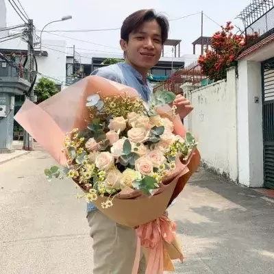 Man holding large pink and white rose bouquet with yellow accents.