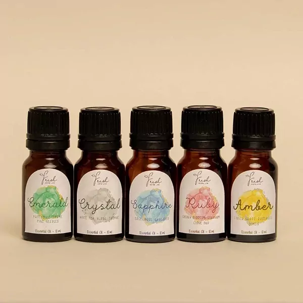 Five small amber glass bottles of essential oils with colorful labels.