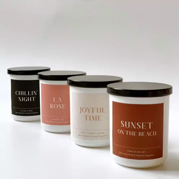 Four scented candles with black lids: "Chillin' Night", "La Rose", "Joyful Time", and "Sunset on the Beach".
