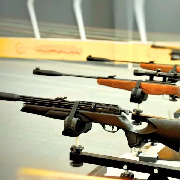 Several rifles on display stands in a shooting range.