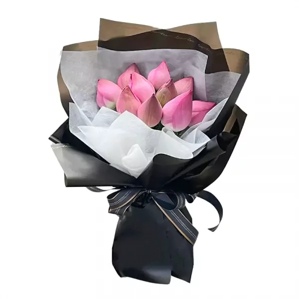 Bouquet of pink lotus flowers wrapped in black and white paper with a ribbon.