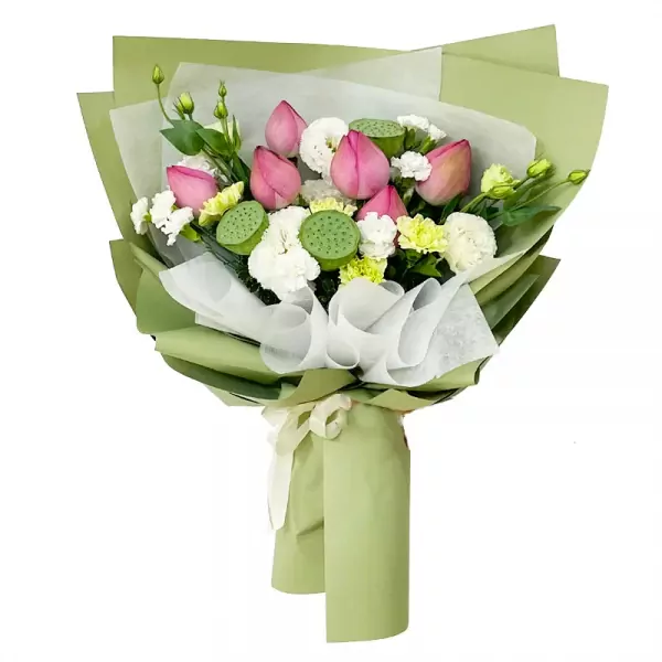 Pink lotus flowers, lotus seed pods, white carnations, and yellow flowers in a green bouquet wrap.