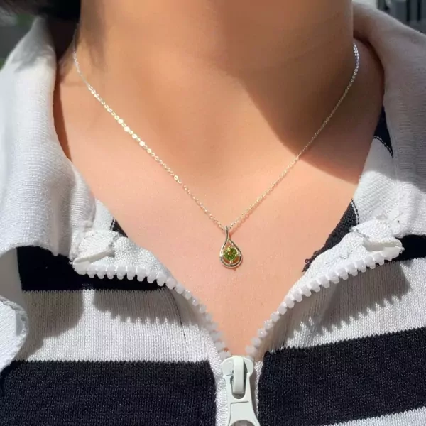 Sterling silver necklace with a teardrop pendant holding a green peridot stone.