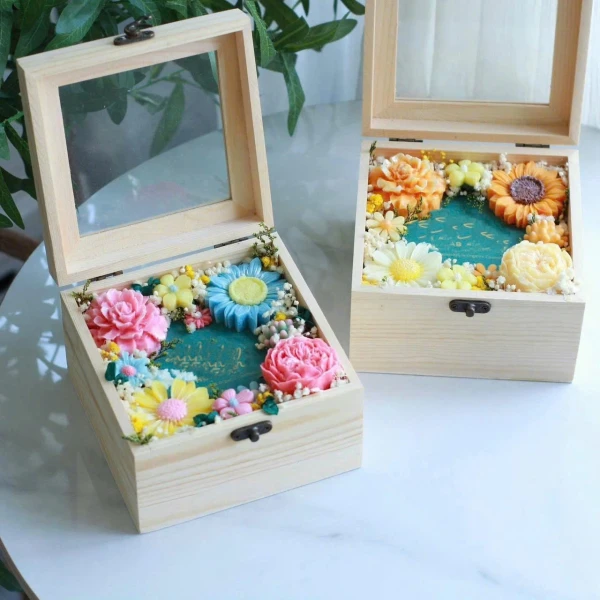 Wooden gift boxes with soap flowers and clear lids.